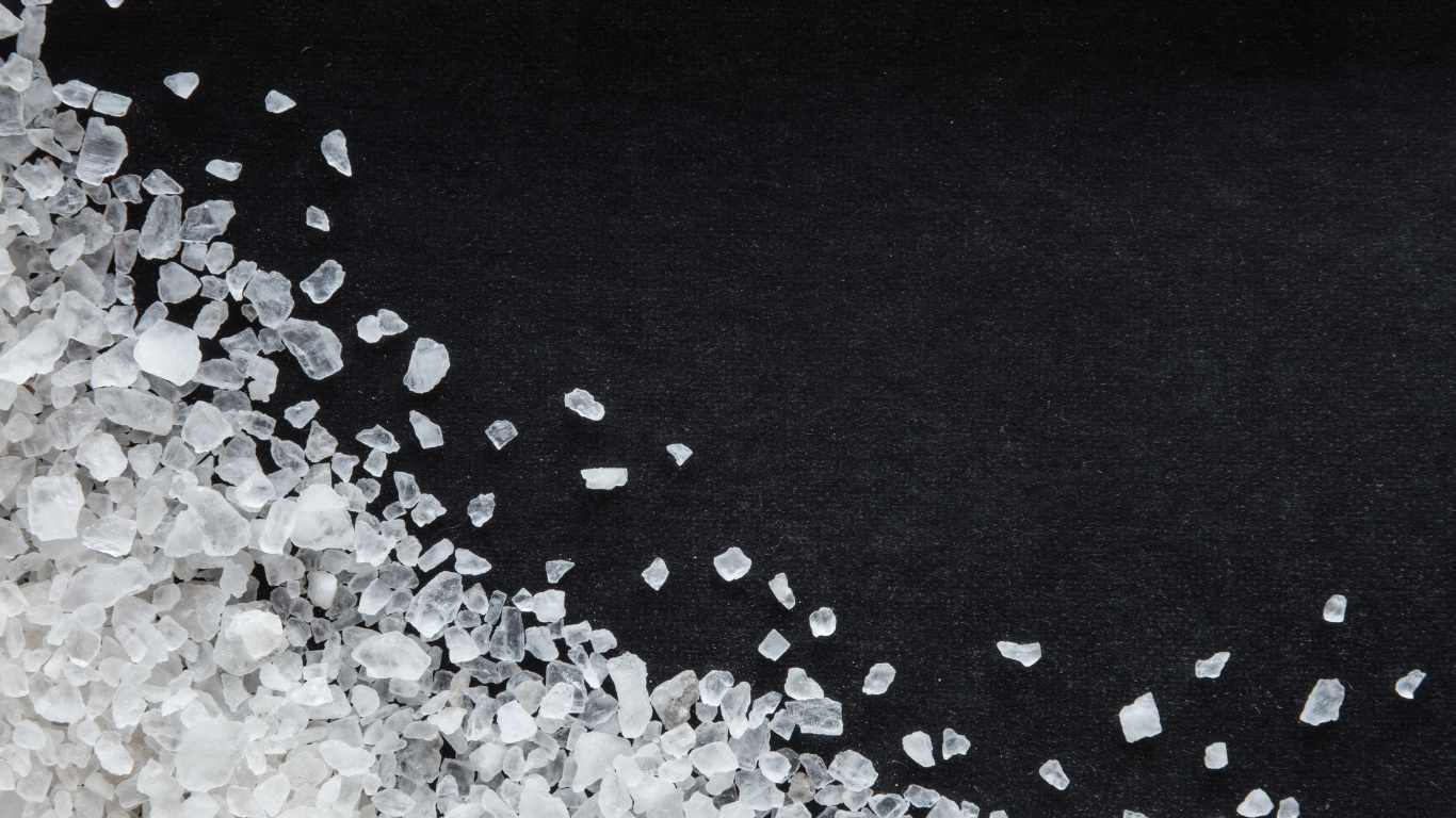 White sand or salt grains on a black background